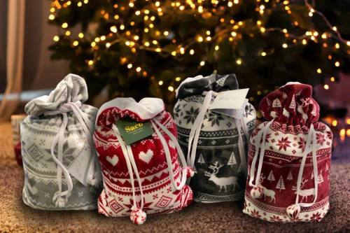 Burgunderrote Weihnachtsdecke von SACO – weich und warm mit Rentieren und Weihnachtsbäumen in einer dekorativen Tasche